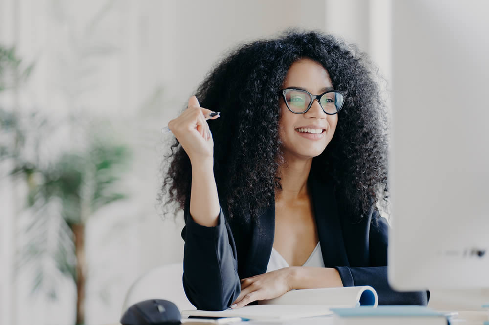 Photo of person smiling with pen and paper